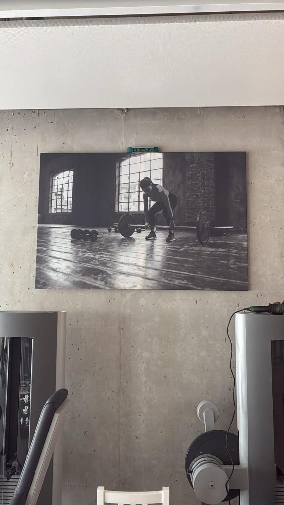 Wandbild mit Frau an einer Langhantel